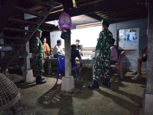 Babinsa Koramil 1420-07/Baranti melakukan patroli malam dan berdialog dengan warga di bawah kolong rumah panggung di Baranti untuk menjaga keamanan wilayah.