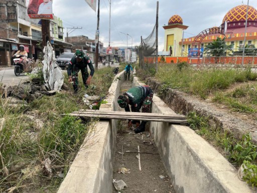 Babinsa Kelurahan Tanru Tedong bersama personel Koramil Dua Pitue membersihkan selokan dan sampah di sekitar Monumen Andi Takko, Sidrap.
