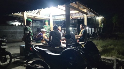 Babinsa Koramil 07 Baranti berdialog dengan warga saat patroli malam di pos ronda Desa Passeno untuk menjaga keamanan dan ketertiban masyarakat.