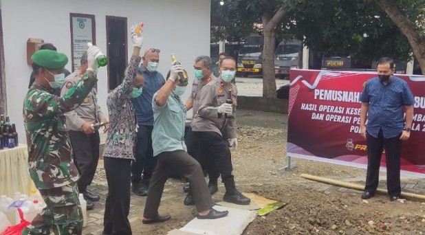 Wakapolres Poso Kompol Suriadi memimpin pemusnahan barang bukti minuman keras hasil Operasi Pekat Tinombala 2026 di halaman Mapolres Poso.