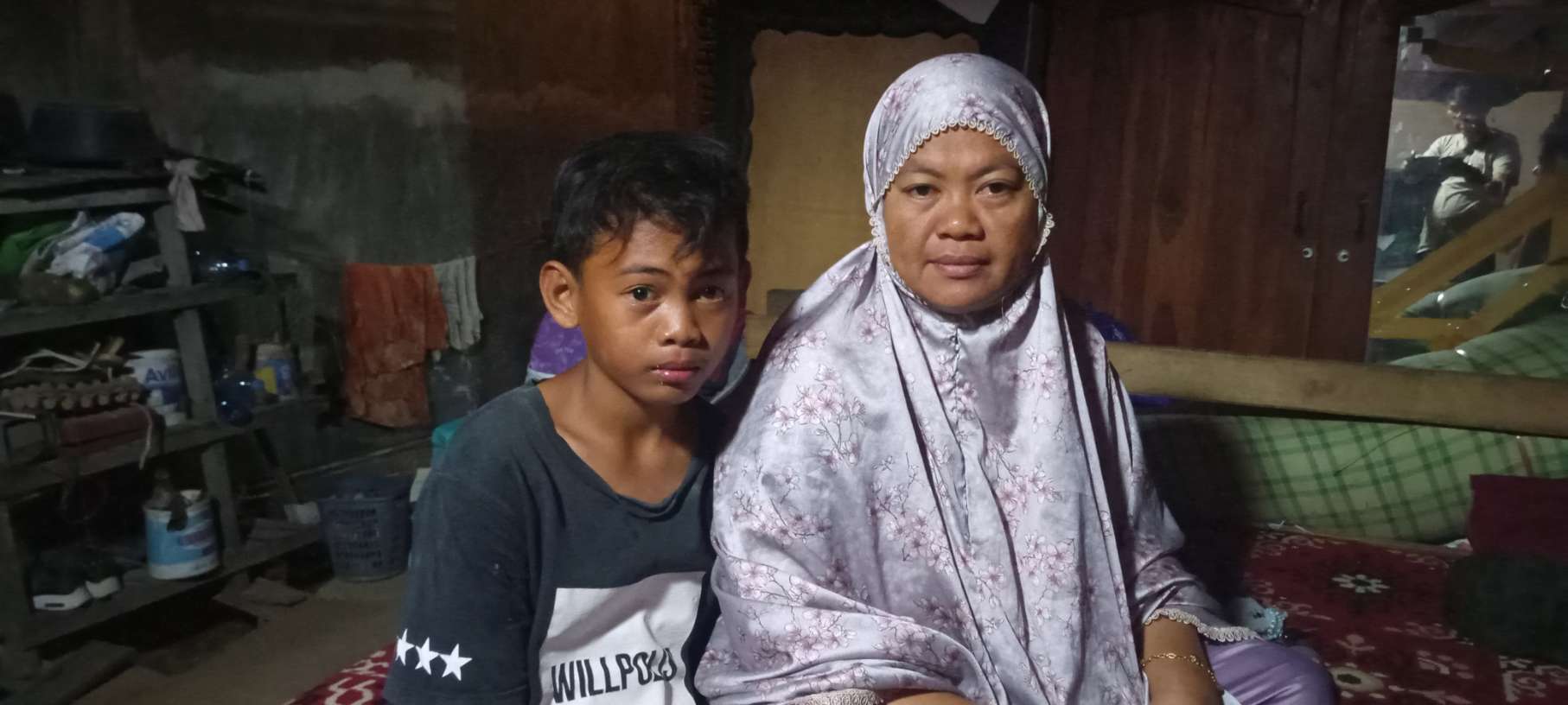 Muh Fais bersama ibunya Fitriani duduk di bawah rumah panggung usai menjadi korban kekerasan di Sidrap